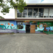 facade of a public building with a mural of flowers and trees.