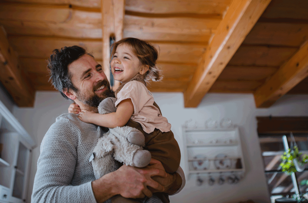 Parent carrying child and stuffed animal.